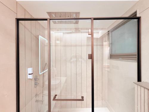 a shower with a glass door in a bathroom at Radiance Hotel in Sirsa