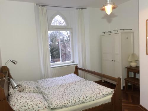 a bedroom with a bed and a window at Lilienthalschlösschen in Berlin