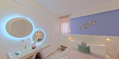 a bedroom with a bed and a table and a mirror at Filomeni Studios in Pefkochori