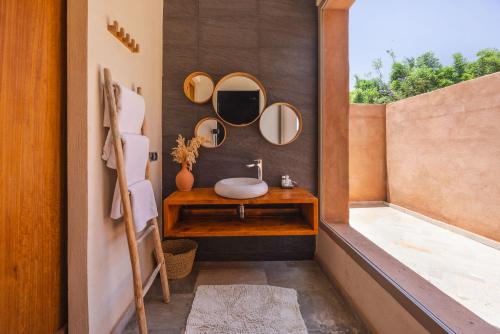 a bathroom with a sink and mirrors on the wall at PALAIS SOHAN in Marrakesh