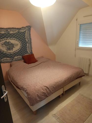 a bedroom with a bed with a pillow and a window at Guest House Erdeven in Erdeven