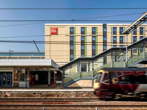 a train on the tracks in front of a building at ibis Cambridge Central Station in Cambridge