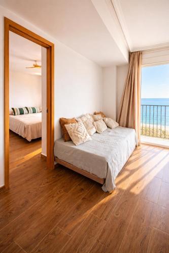 a bedroom with a bed and a large window at Frente al mar , Piscina ,Playa in El Campello