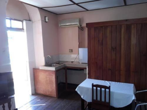 a kitchen with a table and a sink and a counter at Le Valiha Hotel in Antsiranana