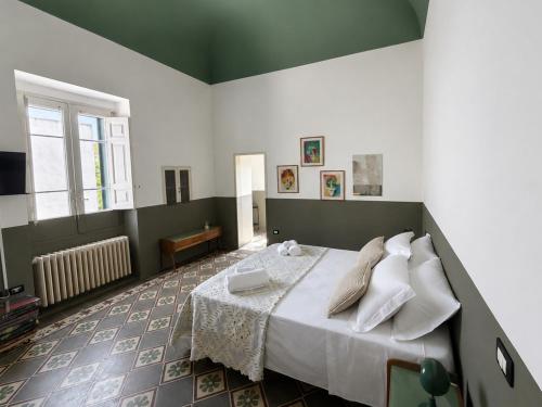 a bedroom with a bed with white sheets and pillows at Palazzo Vite in Copertino