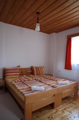 ein großes Bett in einem Zimmer mit Holzdecke in der Unterkunft Baba I Dede in Galičnik