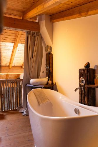 a bath tub in a bathroom with a wooden ceiling at Monte D´Sancho in Aljezur