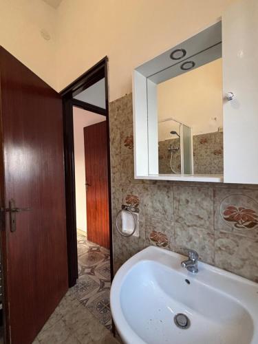 a bathroom with a sink and a mirror at Terrazza delle Acacie in Villaggio San Leonardo