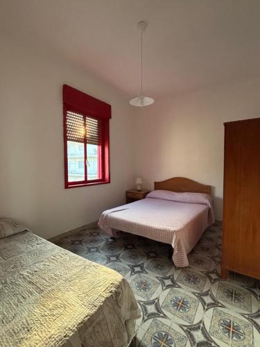 a bedroom with two beds and a window at Terrazza delle Acacie in Villaggio San Leonardo