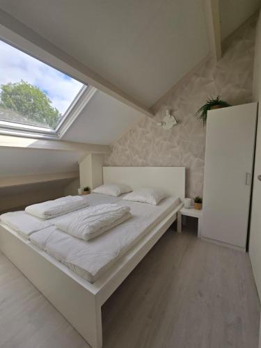 a bedroom with a large bed with a skylight at De Mossel 147 in Bruinisse
