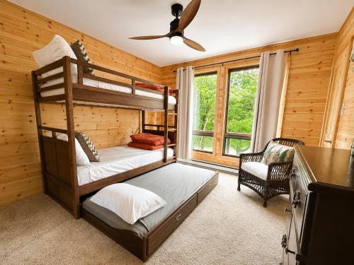 a bedroom with two bunk beds and a ceiling fan at Clocked Out Cabin with Lake Access, Fire Pit, Games in Blakeslee