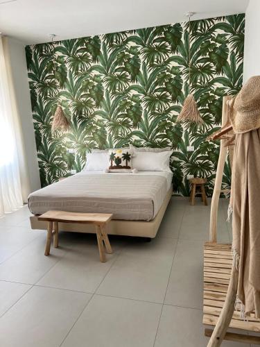 a bedroom with a bed with a tropical wallpaper at Mamma mia rooms in Nola