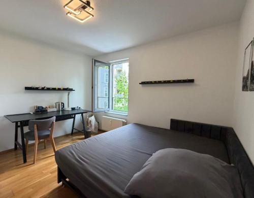 a bedroom with a bed and a desk and a table at Ori's apartment in Frankfurt
