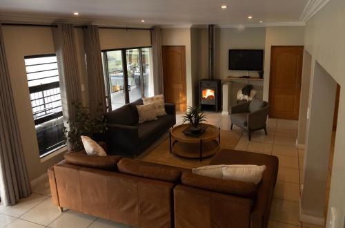 a living room with a couch and a fireplace at Le Vaal Manor in Parys