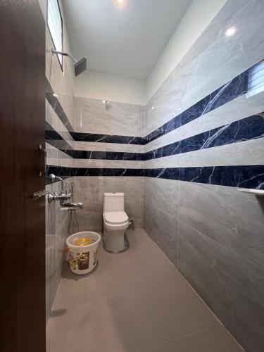a bathroom with a toilet and a flag painted on the wall at VV Guest House & Rooms in Tiruvannāmalai