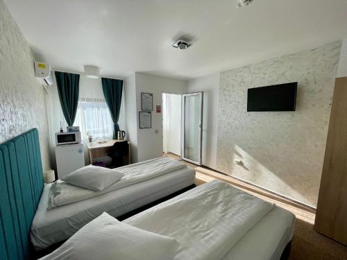 a hotel room with two beds and a television at Academia De Arhitectura in Piteşti