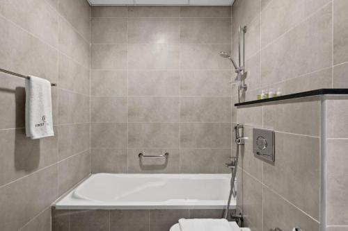 a bathroom with a bath tub and a toilet at FIRST CLASS Studio Inviting Luxury Escape in Dubai Marina