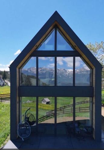 a view of mountains through a window of a house at Serra Chalet in Fundata