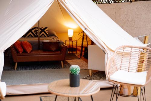a room with a tent with a couch and a table at Glamping Rivera del Mar - RV Park in Loreto