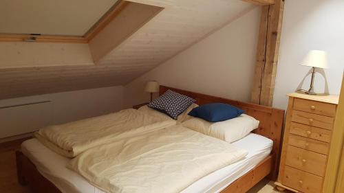 ein Schlafzimmer mit einem Bett und einer Kommode im Dachgeschoss in der Unterkunft Landhaus Hickman in Hopferau