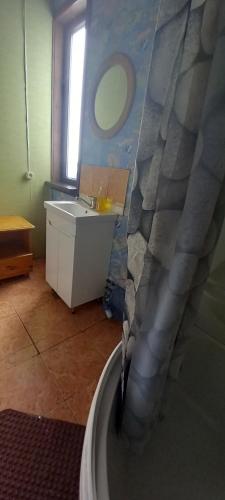 a bathroom with a sink and a bath tub at Kļūda1 in Biksinīki