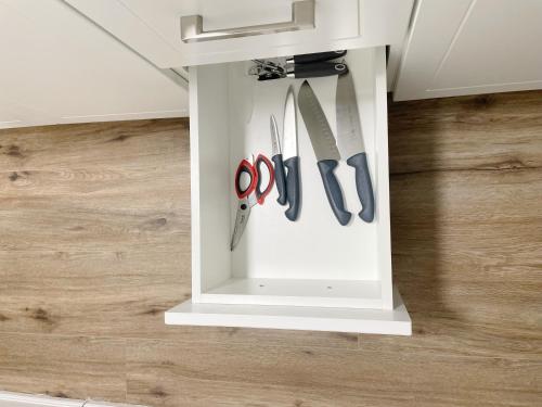 a white cabinet with knives and scissors in it at Cozy 1 Br Apt with TV, Workstation, Kitchenette & Parking in Mississauga