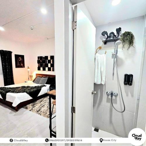 a bathroom with a shower and a bed at Blanc Suite in Roxas City