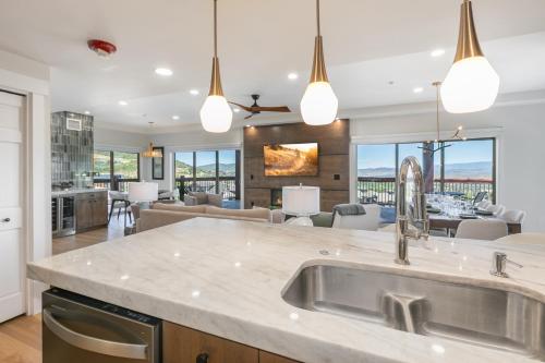 a kitchen with a sink and a living room at Condos at Canyons Resort by White Pines in Park City