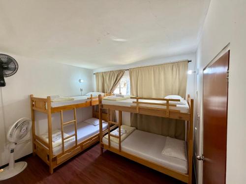 a room with three bunk beds and a window at Hostal Beko in Cali