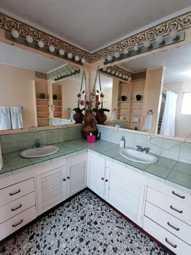 a bathroom with two sinks and a large mirror at Cariari Bed & Breakfast in San José