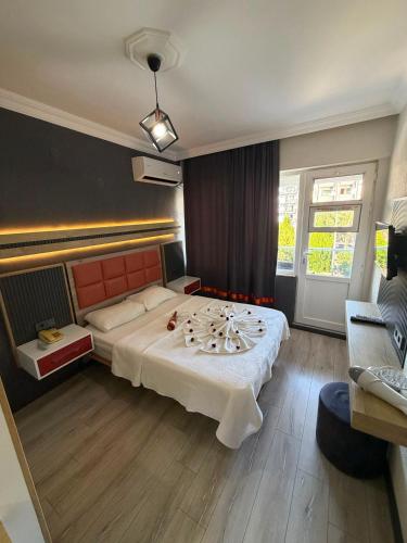 a hotel room with a large bed and a couch at KENT HOTEL Didim in Didim