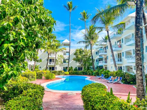 a resort with a swimming pool and palm trees at Tropicana Suites Deluxe Beach Club & Pool Punta Cana SPA in Punta Cana