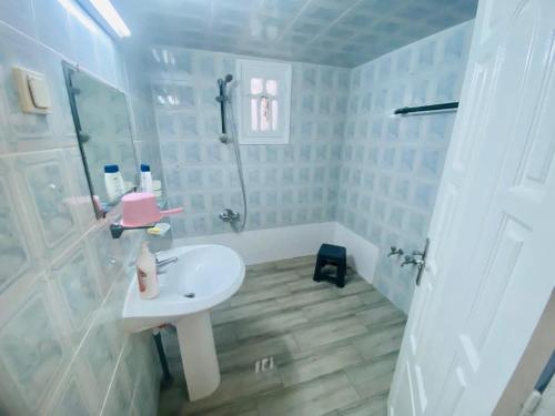a white bathroom with a sink and a shower at Appart AL MARAII - Familles seulement in Beni Khiar