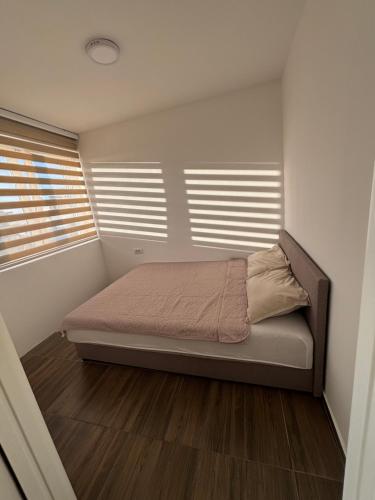 a bedroom with a bed in a room with windows at M apartman in Paraćin