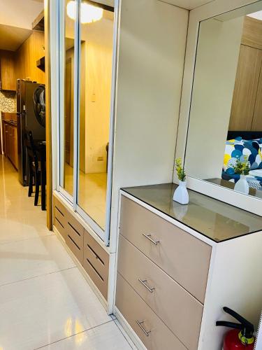 a dressing room with a dresser and a mirror at Shell Residences Manila by PauL in Manila