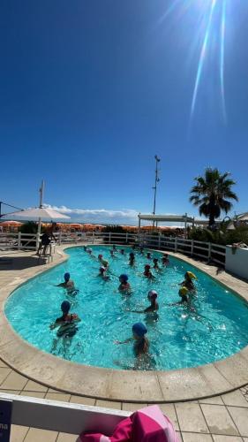 eine Gruppe von Menschen in einem großen Schwimmbecken in der Unterkunft Hotel Sassonia in Fano