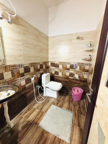 a bathroom with a toilet and a sink at Sai Srushti Homes in Gonikoppal