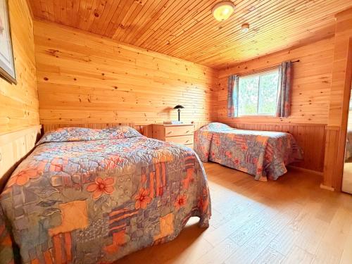 a bedroom with two beds in a wooden cabin at Sundance Cottages in Cavendish