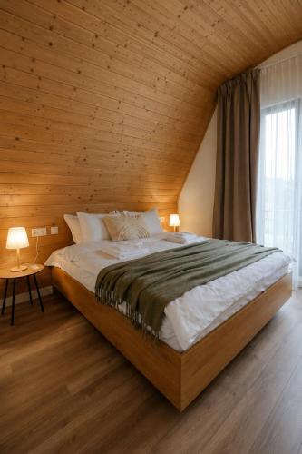 a bedroom with a large bed with a wooden ceiling at Le Cabane Retreat in Lereşti