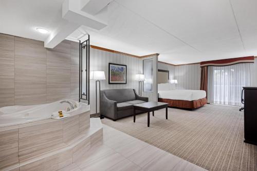 a hotel room with a tub and a bed at Best Western PLUS Port O'Call Hotel in Calgary
