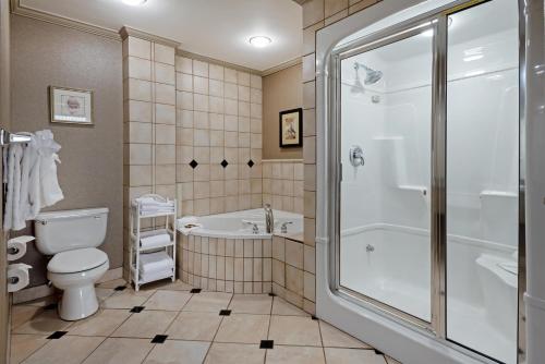 a bathroom with a tub and a toilet and a shower at Best Western PLUS Port O'Call Hotel in Calgary