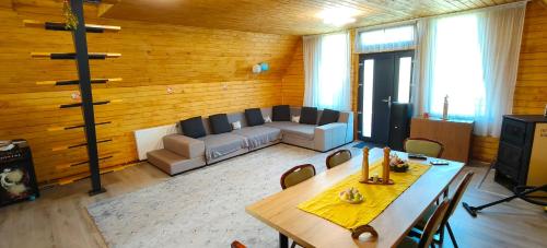a living room with a table and a couch at Cabana A frame Nămăiești in Nămăeşti
