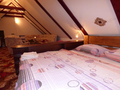 a bedroom with a large bed in a attic at Penzion - Restaurant U Zámku in Bečov nad Teplou