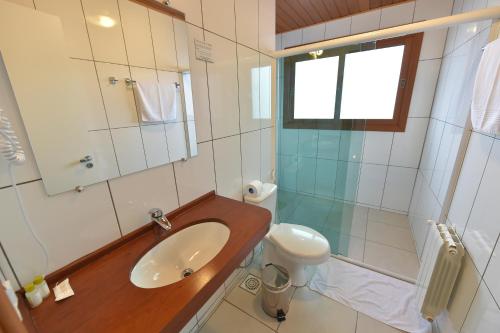 a bathroom with a sink and a toilet at Hotel Villa Aconchego de Gramado in Gramado