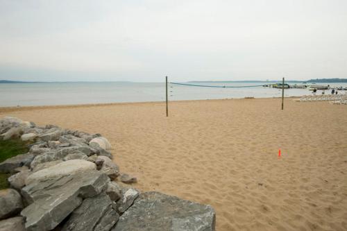 a volleyball net on a sandy beach next to the ocean at Parkshore Resort in Traverse City