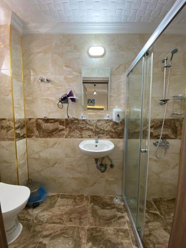a bathroom with a sink and a shower at KENT HOTEL Didim in Didim
