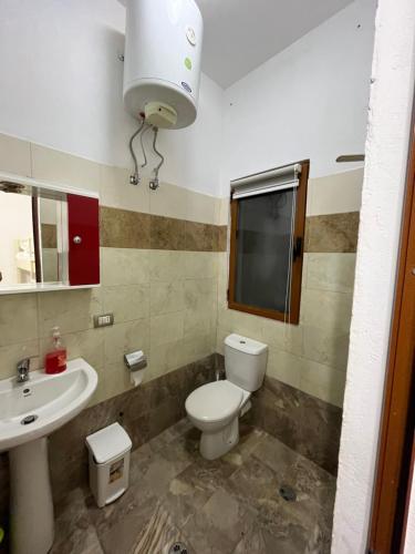 a bathroom with a toilet and a sink at Zefigrillhouse in Tale
