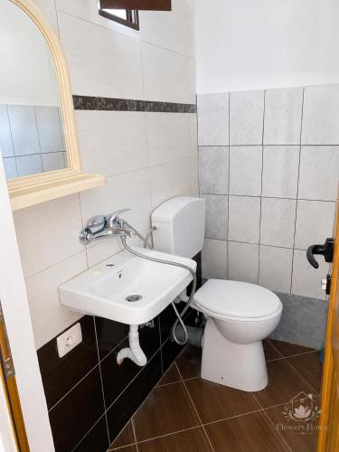 a bathroom with a white toilet and a sink at Flowers House in Gjirokastër