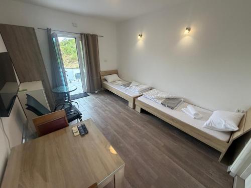 a living room with two beds and a table at B-I Apartmani in Glavatske Kućice
