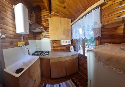 a small kitchen with a sink and a stove at Domek Szumin-Wywłoka in Majdan